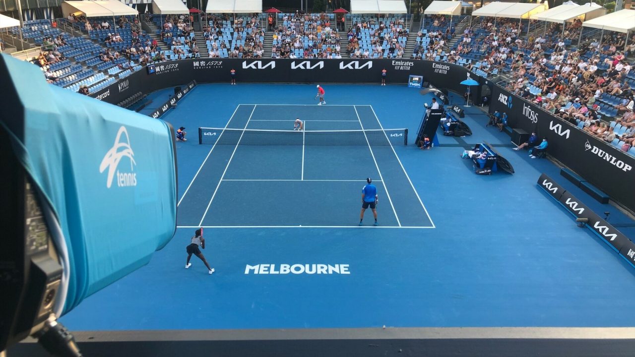 a tennis court with people in the back